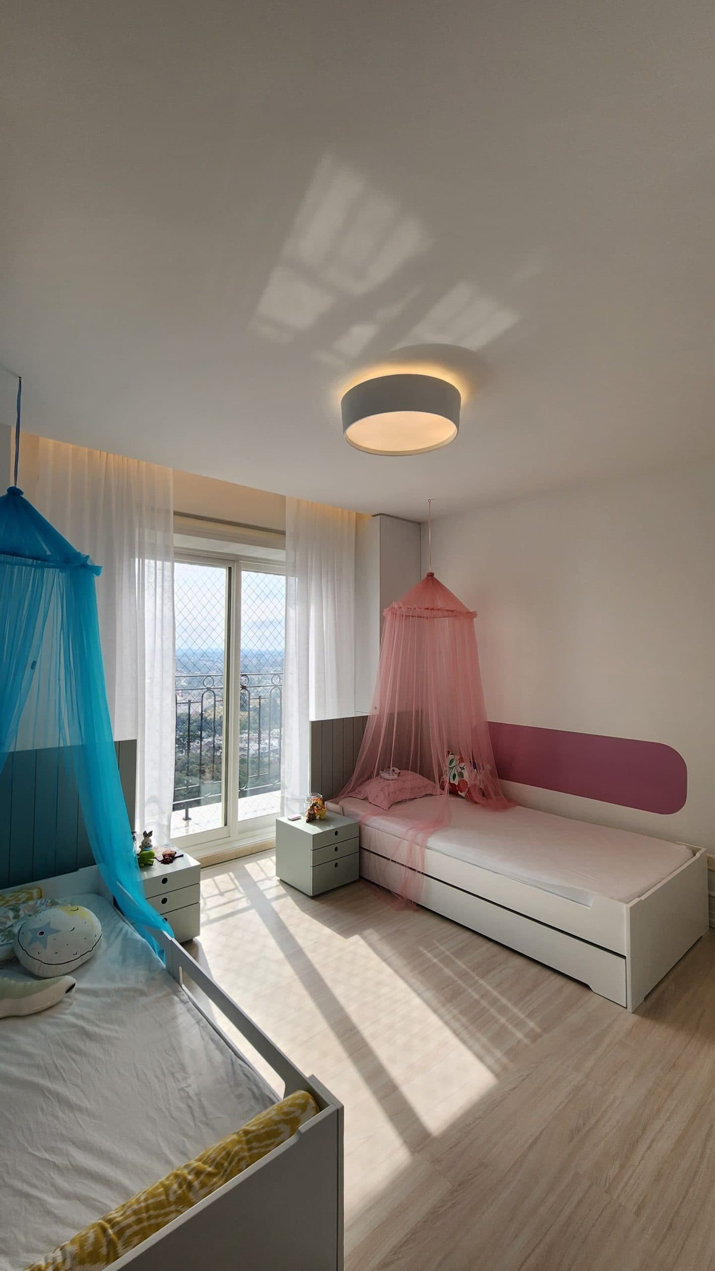 Quarto infantil de menino e menina com móveis sob medida de marcenaria em Curitiba, contém cabeceira e mesa de cabeceira em pintura laca e bicamas