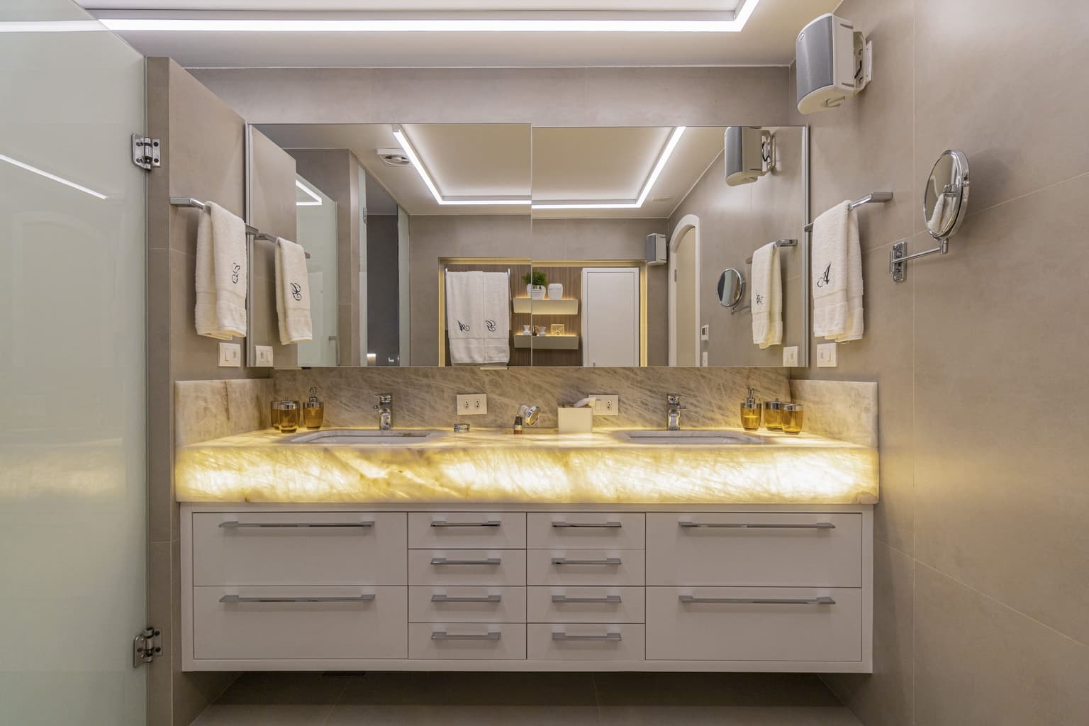 móveis sob medida em banheiro com pedra ônix e iluminação LED, com design moderno